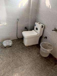 a bathroom with a toilet and a bucket in it at Hotel Geeta Inn in Badrīnāth