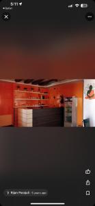 cocina con armarios de color naranja y nevera en Hotel Aakash, en Lumbini