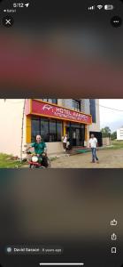 un hombre en una motocicleta delante de un edificio en Hotel Aakash, en Lumbini