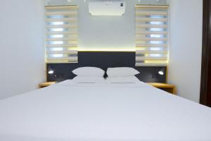 a large white bed in a room with windows at AEGEAN Apartments - Bungalows in Alacati