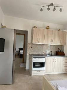 a kitchen with white cabinets and a refrigerator at Flora’s place in Sarandë