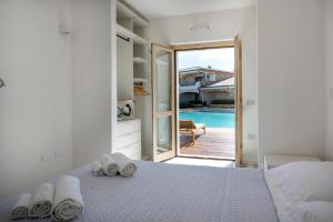 1 dormitorio con 1 cama con toallas en Sardinia Gold Luxury Apartment, en Palau