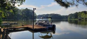 a boat tied up to a dock on a lake at Logan Martin Lake Sunroom in Lincoln