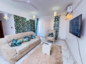 un salon avec un canapé et une chaise dans l'établissement Beachfront-Homes 1st Avenue Nyali, à Mombasa