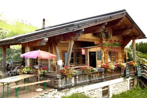 un restaurante con una mesa y una sombrilla delante de él en Berggasthof Rofan, en Maurach