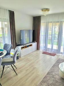 ボーヒニにあるLuxury Apartment near Lake Bohinjのリビングルーム(テレビ、テーブル、椅子付)