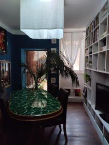 une salle à manger avec une table verte et une plante dans l'établissement Nuovo appartamento in borgo medievale, à Grosseto