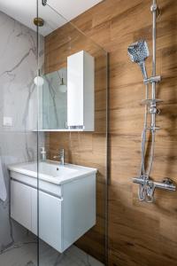 uma casa de banho com um lavatório branco e um chuveiro em TheHouse - Apartment Kamenitza em Velingrad