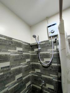 a shower in a bathroom with a tiled wall at Gensan Homey Apartment in General Santos