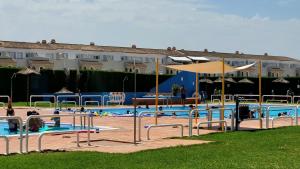 uma grande piscina com pessoas a brincar nela em Casa La Palmera Sunrise em San Pedro del Pinatar