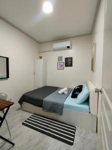 a bedroom with a bed and a desk and a television at Gensan Homey Apartment in General Santos