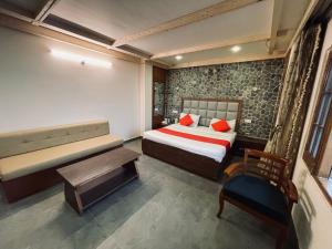 een slaapkamer met een bed, een bank en een tafel bij The Himalayan Escape in Mundaghat 