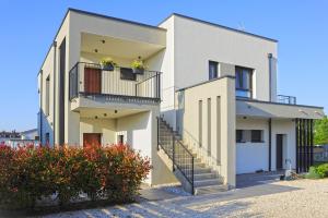 a white house with two balconies and flowers at Black & White Studios in Bale