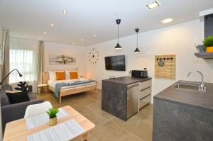 a kitchen and living room with a couch and a bed at Black & White Studios in Bale