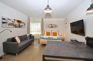 a living room with a couch and a tv at Black & White Studios in Bale