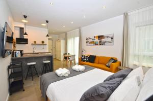 a room with two beds and a kitchen and a couch at Black & White Studios in Bale
