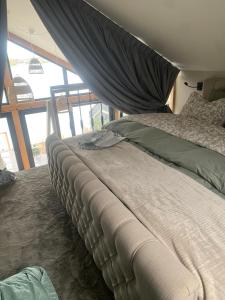 ein großes Bett in einem Zimmer mit einem großen Fenster in der Unterkunft Studio Lakeview in Goes