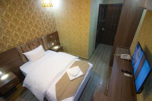 Dormitorio pequeño con cama y TV en فندق بيروت 2 New en Amán