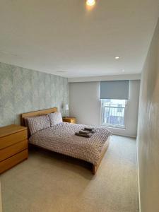 1 dormitorio con cama y ventana en Merchant City Luxury 2 Bedroom Apartment with Secure Parking Available on Request, en Glasgow