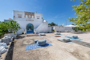 a building with couches and chairs in a yard at Tenuta Miro in Ostuni