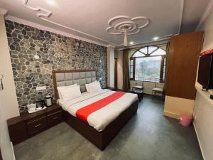 een slaapkamer met een bed en een tv. bij The Himalayan Escape in Mundaghat 