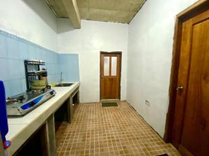 uma cozinha com uma porta castanha e piso em azulejo em Baguio mountain villa view LW em Baguio