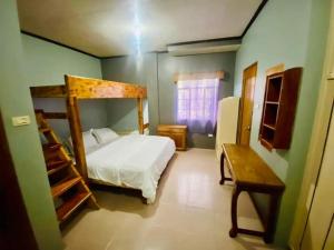 - une chambre avec un lit dans une pièce verte dans l'établissement Baguio mountain villa view LW, à Baguio