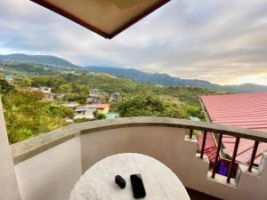 een balkon met een tafel en uitzicht op de bergen bij Baguio mountain villa view LW in Baguio