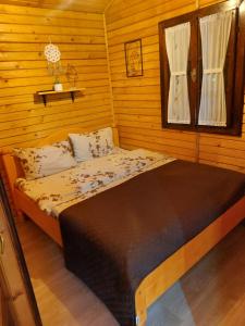 - une chambre avec un lit dans une pièce en bois dans l'établissement Dor de Munte Transfăgarasan, à Cârţişoara