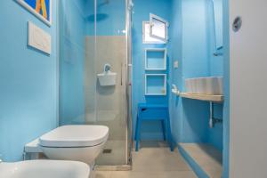La salle de bains bleue est pourvue de toilettes et d'un lavabo. dans l'établissement Tenuta Miro, à Ostuni