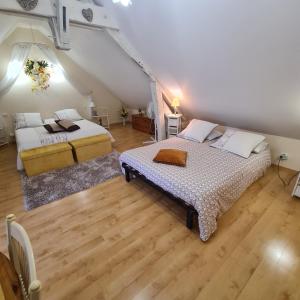 2 camas en una habitación con suelo de madera en Chambres d'Hôtes La Quèrière, en Mur-de-Sologne
