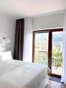 ein Schlafzimmer mit einem Bett und einem großen Fenster in der Unterkunft Apartments Diva in Sarajevo