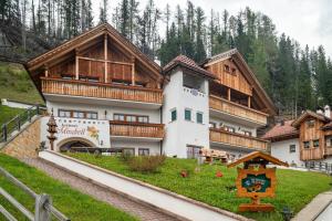 a large building with wooden balconies on a hill at Apartments Mirabell in Livinallongo del Col di Lana