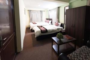 una camera d'albergo con due letti e un tavolo di Yeti Cozy Hotel a Kathmandu