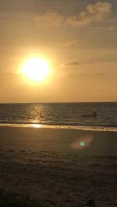 un tramonto sulla spiaggia con il sole che tramonta di Casa de praia a Maceió
