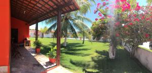 una vista esterna di un cortile con alberi e fiori rosa di Casa de praia a Maceió Altre 6 foto