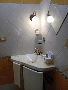 bagno con lavandino con due luci e servizi igienici di Margy House a Morciano di Leuca