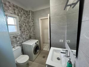 a bathroom with a toilet sink and a washing machine at Chayofa Blue in Chayofa