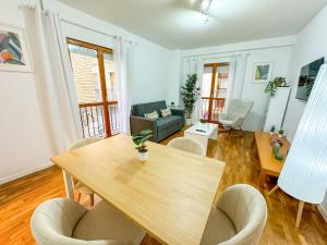 Una sala de estar con una mesa y sillas de madera. en Laurel del Pilar ComoTuCasa, en Zaragoza