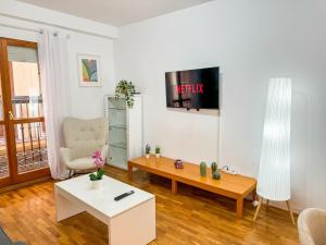 a living room with a coffee table and a tv at Laurel del Pilar ComoTuCasa in Zaragoza