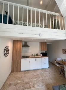 una cucina con armadi bianchi e un soppalco di Duplex a 2 pas de la vielle ville d Avignon ad Avignone