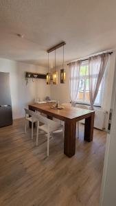 uma sala de jantar com uma grande mesa de madeira e cadeiras em Ferienhaus Bühlertal mit 3 Fewos em Bühlertal