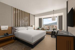 a bedroom with a large bed and a living room at Chiang Mai Marriott Hotel in Chiang Mai +122 photos