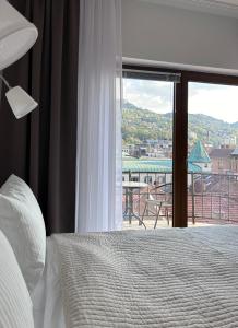 ein Schlafzimmer mit einem Bett und einem Fenster mit Aussicht in der Unterkunft Apartments Diva in Sarajevo