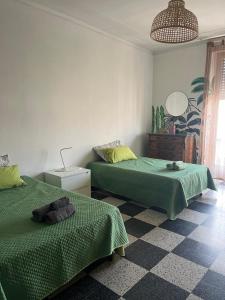 a room with two beds with green sheets on them at Casa GIULIVA in Alessandria