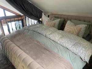 een groot bed met kussens in een slaapkamer bij Studio Lakeview in Goes