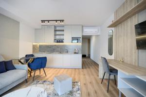 cocina y sala de estar con sofá y mesa en AboutArtApartments - Otyńska 4, en Wroclaw