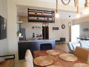 uma cozinha e sala de estar com uma mesa de madeira em Paramount Gardens Resorts C201 em Lárnaca