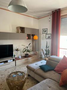 a living room with a couch and a flat screen tv at Casa GIULIVA in Alessandria