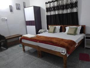 ein Schlafzimmer mit einem großen Bett in einem Zimmer in der Unterkunft Goroomgo Hotel Happy Home Stay Khajuraho in Khajurāho